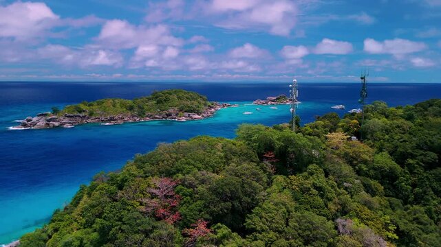 Tropical island landscape of the Similan Islands in the Andaman Sea, Thailand, featuring crystal clear turquoise water, white sand beach, and lush tropical forest.