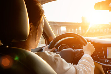 Female driver driving a car from the rear seat perspective