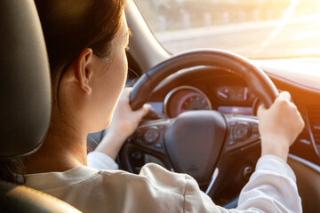 Female driver driving a car from the rear seat perspective
