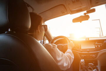 Female driver driving a car from the rear seat perspective
