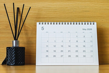 Office desk calendar showing May 2026 with copy space on wooden background, ideal for business planning, scheduling, and time management concepts.