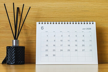 Office desk calendar showing June 2026 with copy space on wooden background, ideal for business planning, scheduling, and time management concepts.
