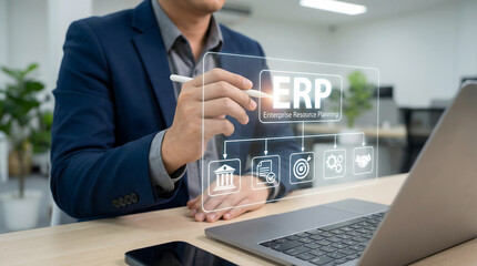 Professional businessman uses a digital stylus interacting with a holographic ERP system in a modern
