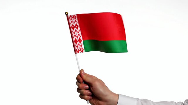 Hand holding waving flag of Belarus on white background