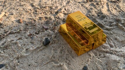 view of gold bars and sandy soil background, suitable for wealth or investment, photo concept © MR HEPPY