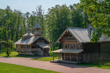 Chapel from the village Kashira and the log residential house from the village of Chastova in the Vitoslavlitsi open-air Museum of Folk Wooden Architecture on a summer day, Veliky Novgorod, Russia