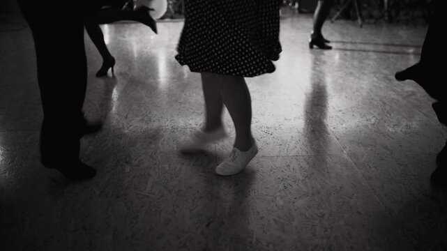 4K close-up couple legs expressive swing dancing in ballroom. Women in sexy dresses, stockings and high heels. Retro style vintage dance, funny leisure time and social dance concept