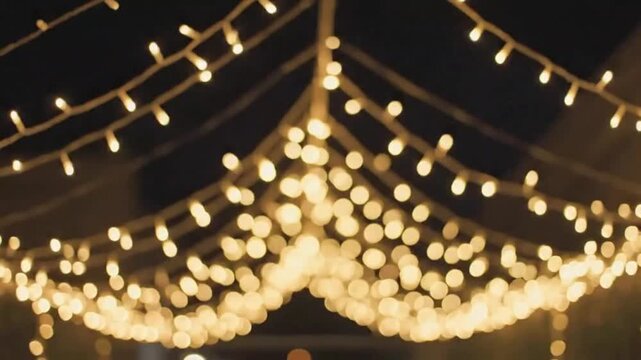 Warm white string lights hanging overhead like a glowing canopy at night, soft bokeh festive ambience, 4K holiday and event background video for weddings, patios, parties and restaurant marketing