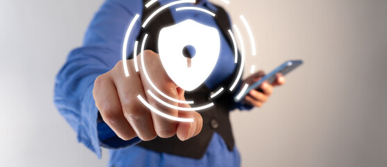 A business professional, pointing to an abstract symbol of security and data protection on her smartphone screen.