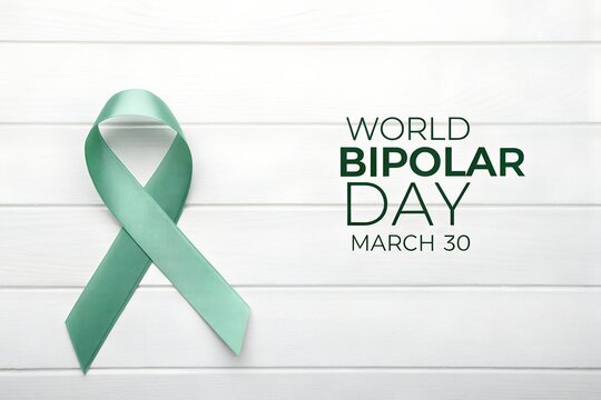 Awareness ribbon representing world bipolar day on march thirtieth displayed against a clean white wooden background promoting mental health support and understanding globally