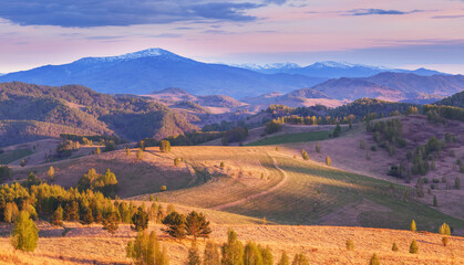 Mountain view in sunset light, evening countryside, hills and meadows