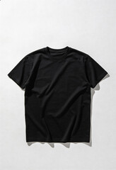 A black t-shirt lies crumpled on a plain white background