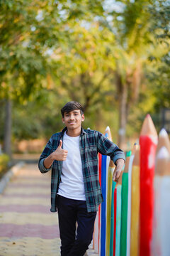 young indian college boy showing thumps up