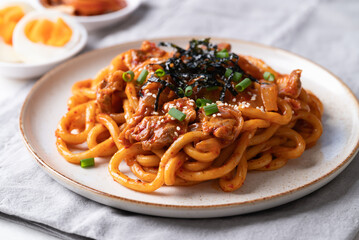 Stir fried Udon noodle with kimchi cabbage, pork, spring onion, sesame seed and seaweed on top