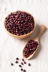 Azuki beans, Adzuki bean or red mung beans in wooden bowl and spoon on white fabric background, Food ingredients in many Chinese dishes and filling in Japanese sweet
