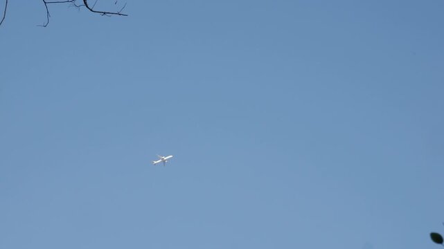 Commercial Airplane Flying High in Clear Blue Sky - Aviation Travel Concept