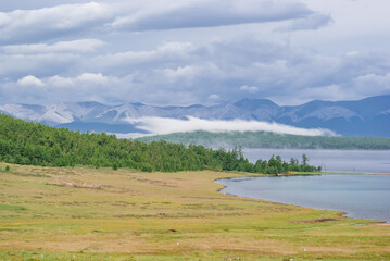 Landscape of snow covered mountains beside the Hovsgol lake. Traveling through norht of Mongolia