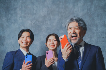 スマートフォンを手に持って喜ぶビジネスマン