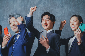 スマートフォンを手に持って喜ぶビジネスマン