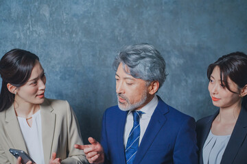 秘書に指示を出すエグゼクティブな50代ビジネスマン