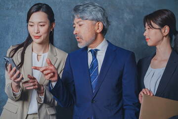 秘書に指示を出すエグゼクティブな50代ビジネスマン