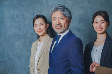 エグゼクティブな50代ビジネスマンと美人秘書チーム