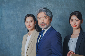 エグゼクティブな50代ビジネスマンと美人秘書チーム