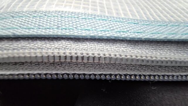 Macro shot of white reinforced plastic mesh texture showing detailed grid pattern and industrial synthetic material.