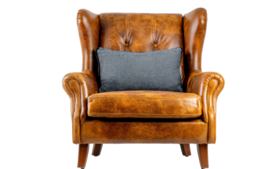 Vintage brown leather wingback armchair with patterned cushion isolated on transparent background. Brown leather wingback armchair with pillow on white background.