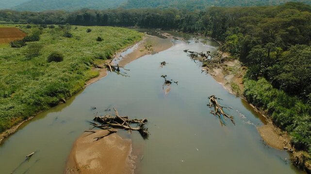 Aerial view of Tarcoles River with fallen trees in rural Costa Rica