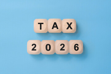 Tax 2026 - phrase from wooden blocks with letters, Tax time 2026 concept, top view blue background