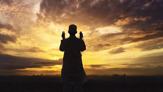 A cinematic 8-second video of a male Muslim in silhouette performing prayer during a vibrant sunset with a timelapse of dramatic clouds moving across a golden sky
