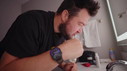Adult man brushing teeth in modern bathroom, daily hygiene routine at home, close up lifestyle scene focused on personal care, health habits, cleanliness and self care
