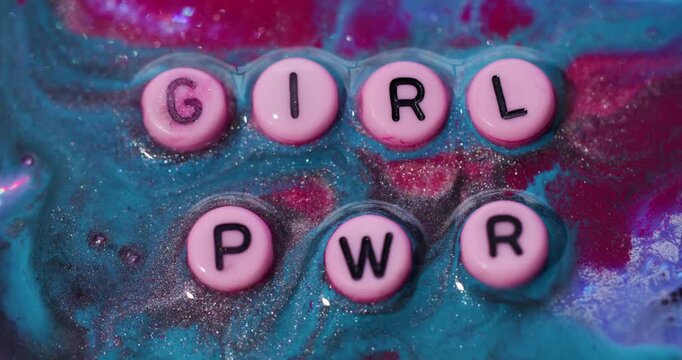 Girl pwr text. Shiny ink. Defocused pink blue red color glitter water sparkling mix fluid black power letters confidence texture on abstract background.