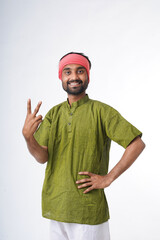 Naklejka premium happy young indian farmer standing on white background