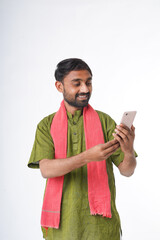 young indian farmer holding smartphone standing on white background