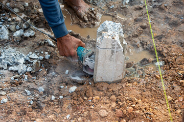 Obraz premium Industry insight construction worker cutting concrete foundation outdoors