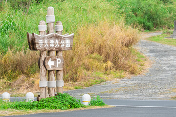 アニメ風の離島の公園入口、手久津久公園の看板と坂道の風景（喜界島・背景素材・コピースペース）