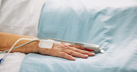 Hand, hospital bed and oximeter for recovery, finger and check pulse with healthcare services. Elderly person, medical equipment and monitor for cardiology, assessment and rehabilitation at clinic