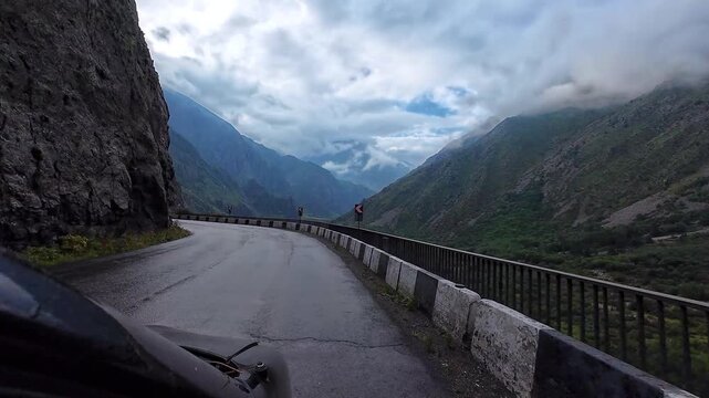Georgia, August 28, 2024: Traveling along the Georgian Military Highway in the Caucasus Mountains. Crossing a pass. View of the mountains from a moving car window in summer. 4K