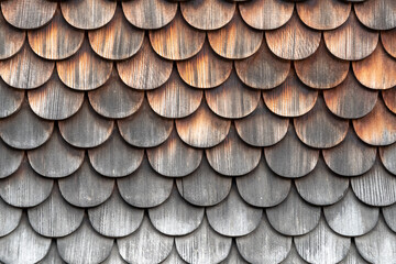 Weathered scalloped wooden shingles creating a natural pattern