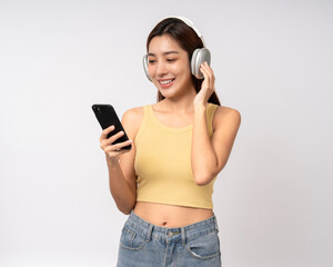 Naklejka premium Beautiful young asian women choose song and play music from smartphone connection with wireless headphone having fun. Teenage girl listen to the music enjoy relaxing on isolated white background.