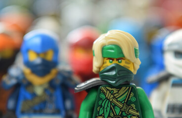 Naklejka premium Editorial illustrative image of lego ninjago minifigure of green ninja Lloyd selective focus on blurred background of ninja team.