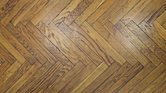 Close look at wooden floor with herringbone pattern in indoor setting during daylight hours