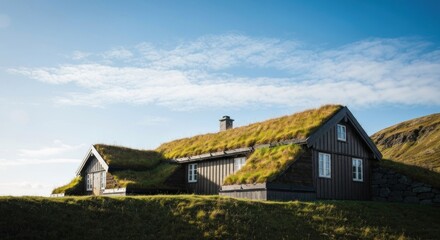 Cozy, wooden home with a grass-covered roof nestled against a hill under a clear sky