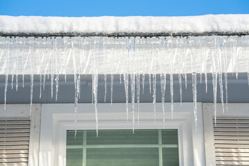 winter house with icicle and snow on the roof