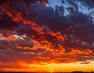 Obraz premium Dramatic sunset sky with vibrant orange, red, and purple hues. Dark clouds. Golden light
