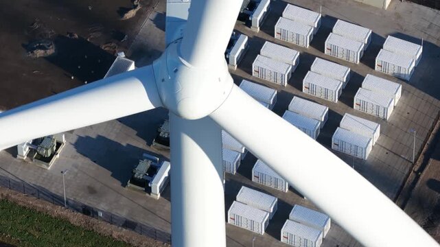 Aerial drone view of wind turbines, battery storage system, and electrical substation at Dronten wind park in the Netherlands.