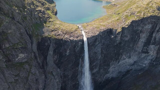 Mardalsfossen Waterfall In More og Romsdal, Norway - Towering Waterfall With Water Plunging Into Lake. aerial pullback, slow motion