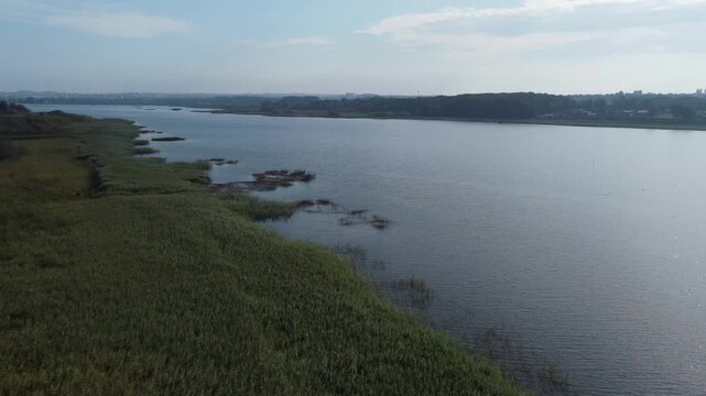 Smooth aerial drone footage showing Brabrand Lake and its natural surroundings in Denmark.